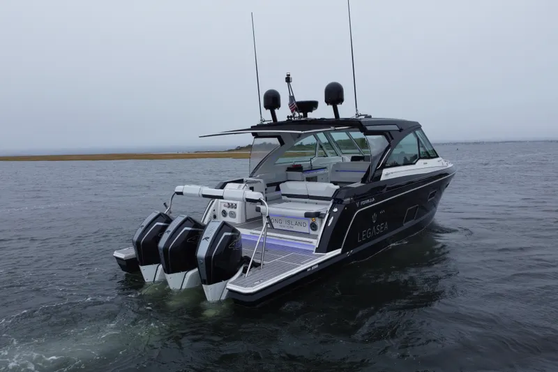 Slide: The Image of 2022 Formula 380 Super Sport Crossover OB boat on water, featuring triple outboard engines. - 14