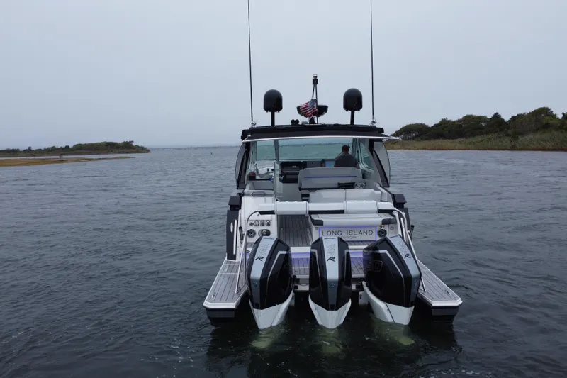 Slide: The Image of 2022 Formula 380 Super Sport Crossover OB on water, rear view, Long Island backdrop. - 15