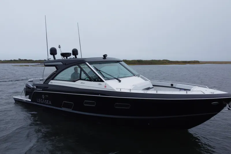 Slide: The Image of 2022 Formula 380 Super Sport Crossover OB boat on water, sleek black design. - 3