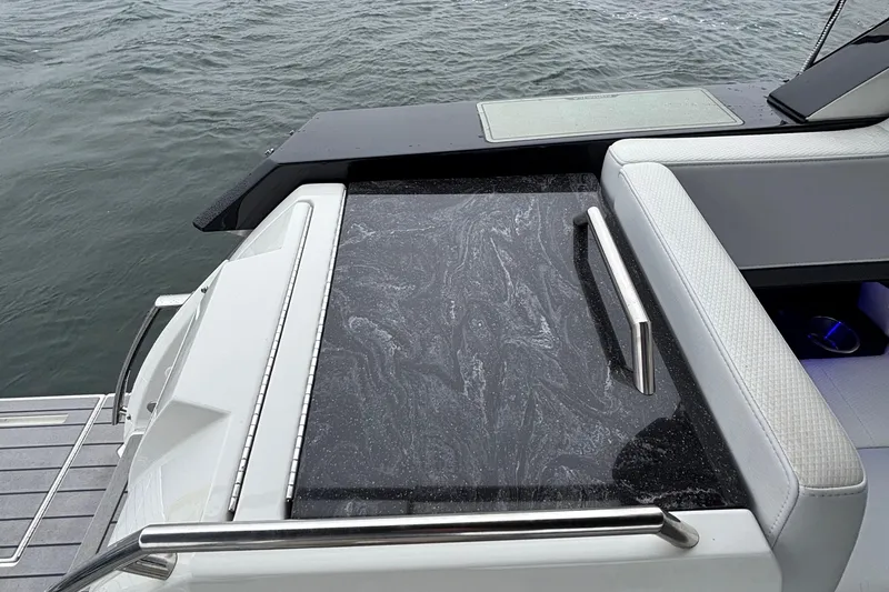 Slide: The Image of 2022 Formula 380 Super Sport Crossover OB boat with sleek black countertop and white seating. - 49