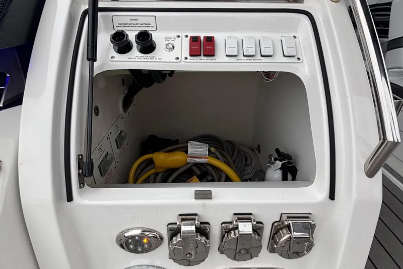 Slide: The Image of 2022 Formula 380 Super Sport Crossover OB control panel with switches and storage compartment. - 53