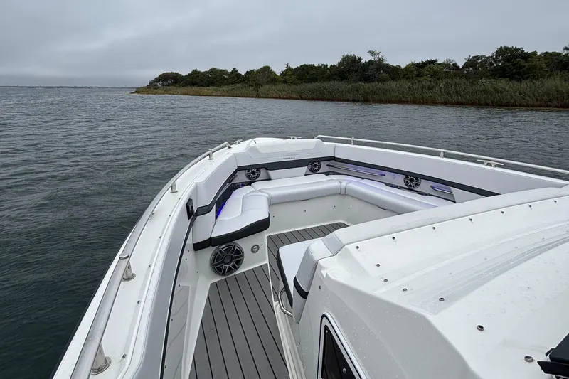 Slide: The Image of 2022 Formula 380 Super Sport Crossover OB boat on calm water, featuring spacious seating. - 63