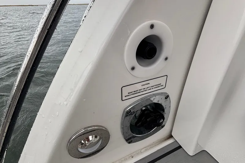 Slide: The Image of 2022 Formula 380 Super Sport Crossover OB boat detail with caution label and water connection. - 95