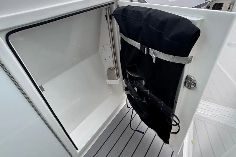 Slide: The Image of 2022 Formula 380 Super Sport Crossover OB storage compartment with black cover and secure latch. - 96