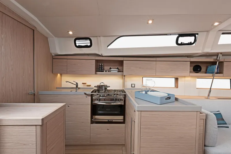 Slide: The Image of Modern kitchen interior of 2024 Beneteau Oceanis 46.1 yacht with light wood cabinetry. - 31
