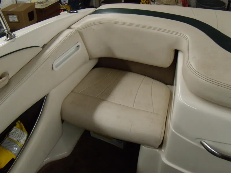 Slide: The Image of 2000 Chaparral 235 SSi boat interior with beige seating and storage compartment. - 3