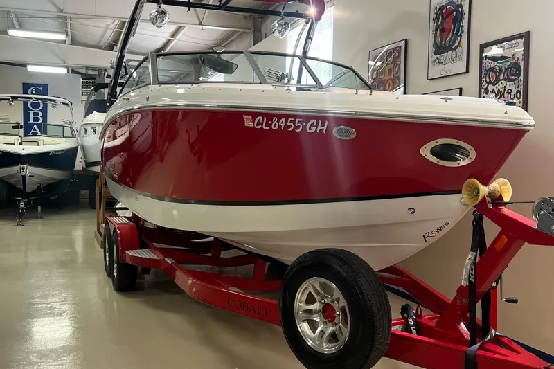Slide: The Image of 2016 Cobalt R5 WSS red and white boat on trailer in indoor showroom. - 7