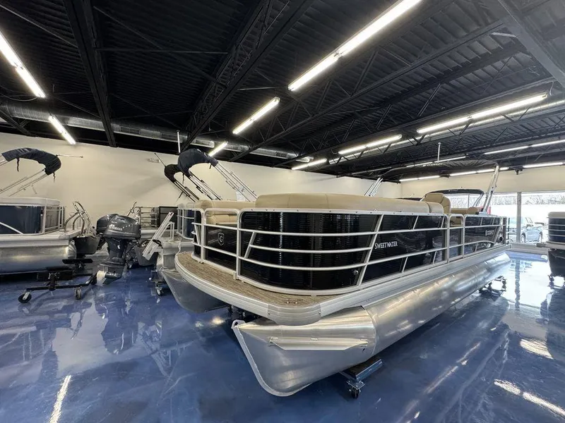 Slide: The Image of 2023 Godfrey SW 2486 SFL pontoon boat displayed in a showroom. - 1