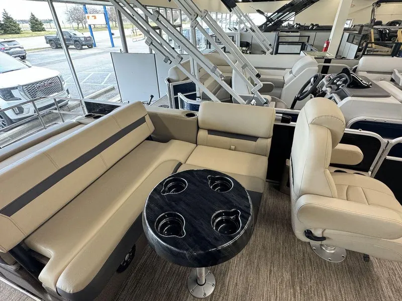 Slide: The Image of 2023 Godfrey SW 2486 SFL boat interior with beige seating and black table. - 8
