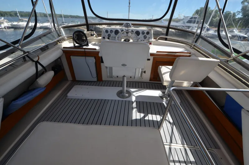 Slide: The Image of 1986 Silverton 40 Aft Cabin boat cockpit with steering wheel and seating. - 11