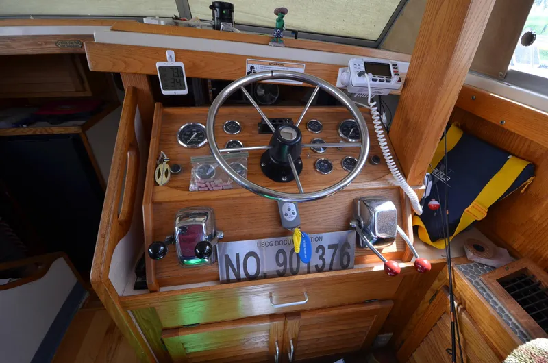 Slide: The Image of 1986 Silverton 40 Aft Cabin boat helm with steering wheel and navigation instruments. - 14