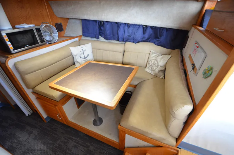Slide: The Image of Cozy dining area in a 1986 Silverton 40 Aft Cabin yacht with beige seating and a wooden table. - 15
