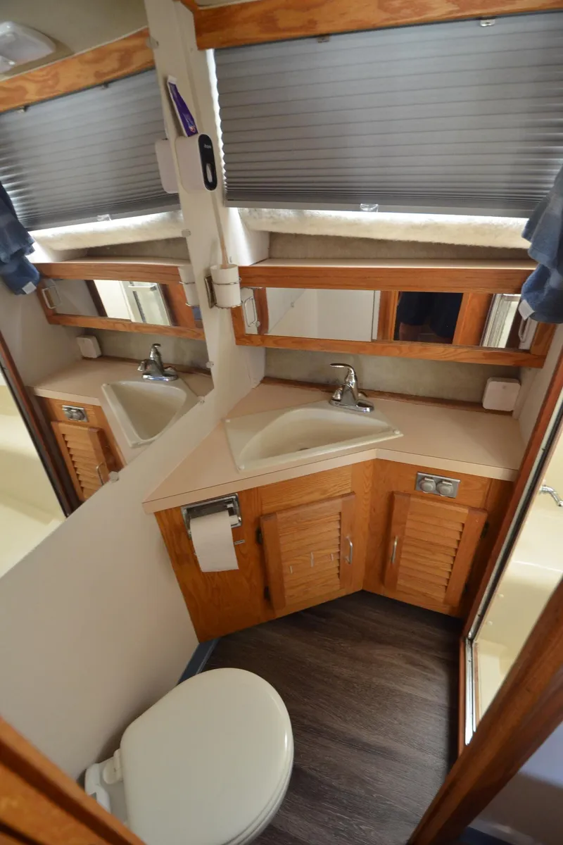 Slide: The Image of 1986 Silverton 40 Aft Cabin bathroom with sink, mirror, and toilet. - 16