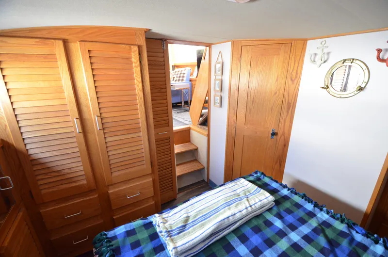 Slide: The Image of 1986 Silverton 40 Aft Cabin interior with wooden cabinets and cozy bedding. - 24