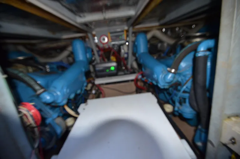 Slide: The Image of Engine room of a 1986 Silverton 40 Aft Cabin boat with twin blue engines. - 31