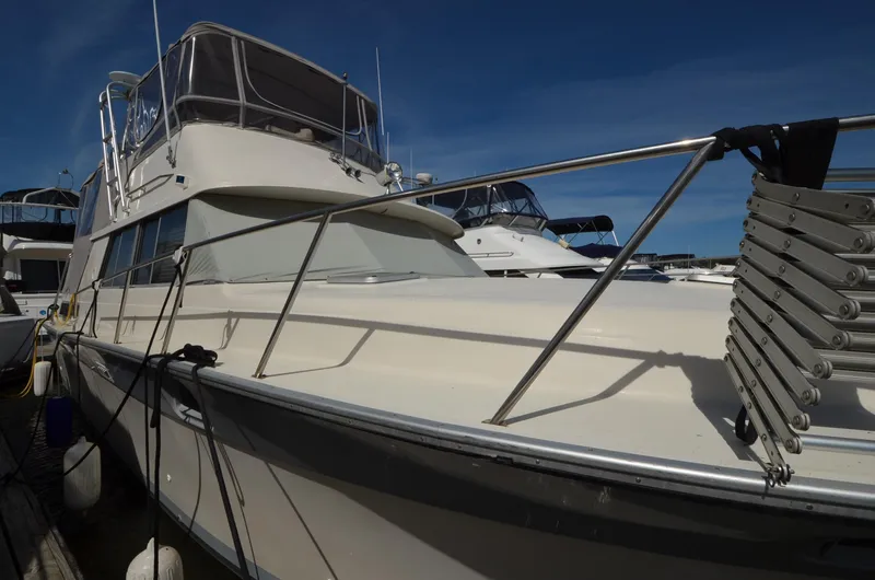 Slide: The Image of 1986 Silverton 40 Aft Cabin yacht docked at marina under clear blue sky. - 4