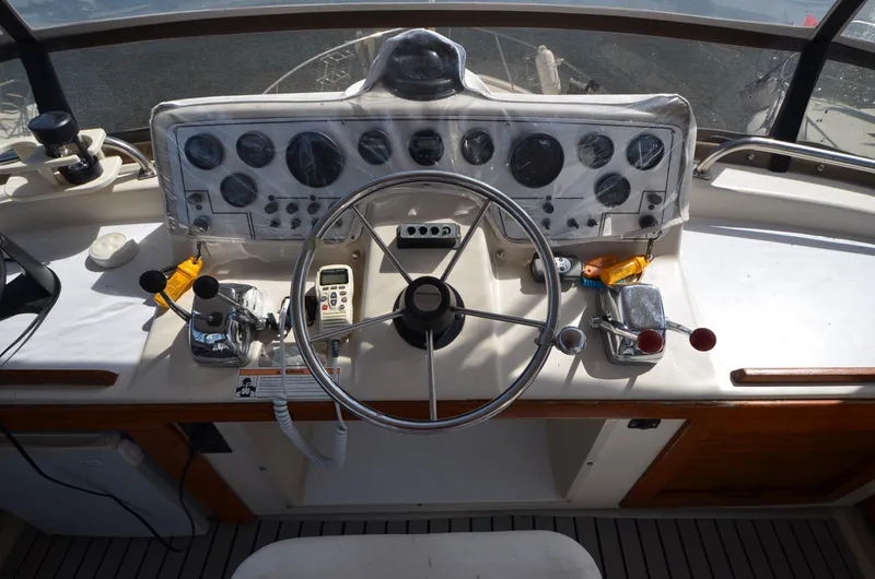Slide: The Image of 1986 Silverton 40 Aft Cabin boat helm with steering wheel and control panel. - 6