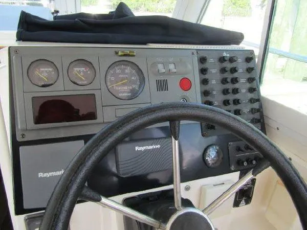 Slide: The Image of 2000 Albin Tournament Express boat dashboard with Raymarine electronics and steering wheel. - 16