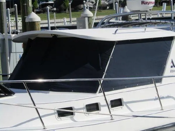 Slide: The Image of 2000 Albin Tournament Express boat docked, close-up of cabin windows and railing. - 3