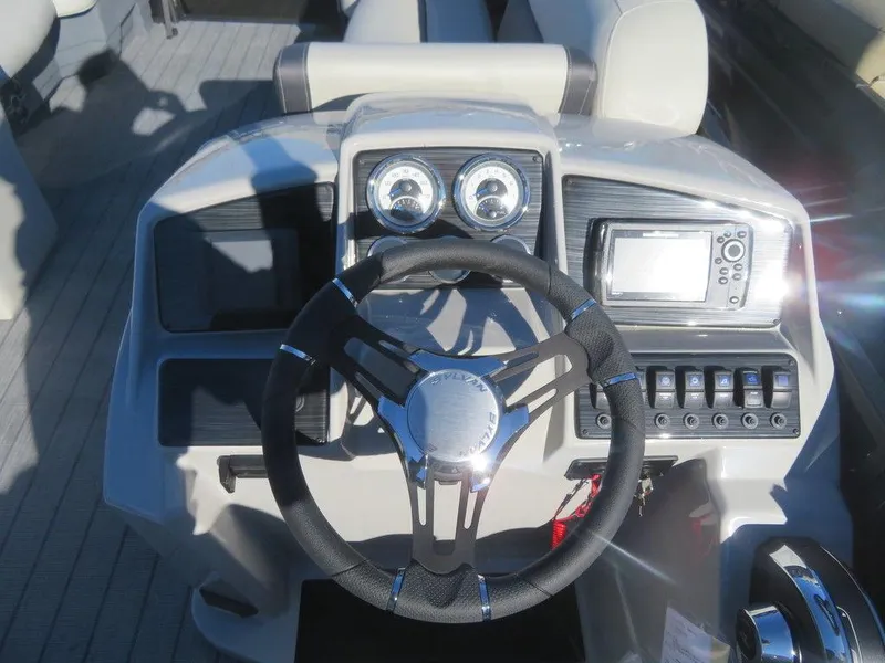 Slide: The Image of 2023 Sylvan Mirage X5 boat dashboard with steering wheel, gauges, and control panel. - 12