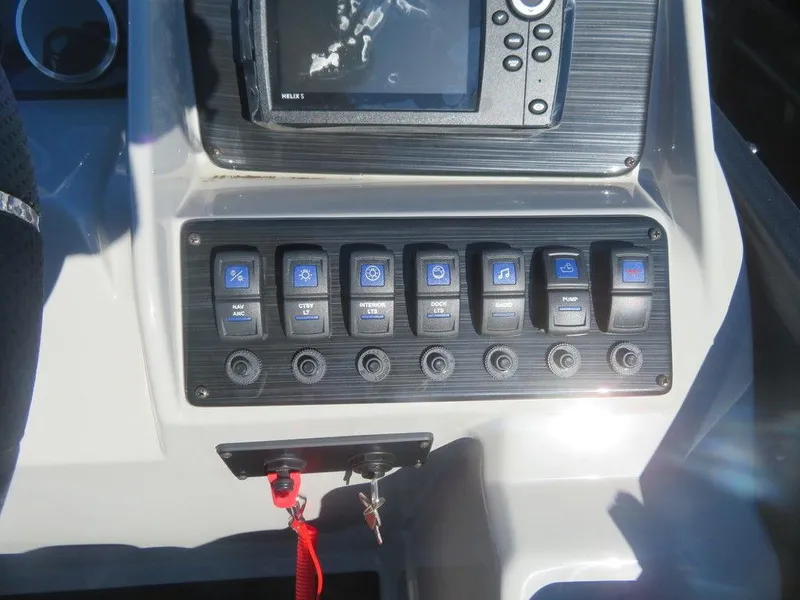 Slide: The Image of Control panel of a 2023 Sylvan Mirage X5 boat with switches and a display screen. - 14