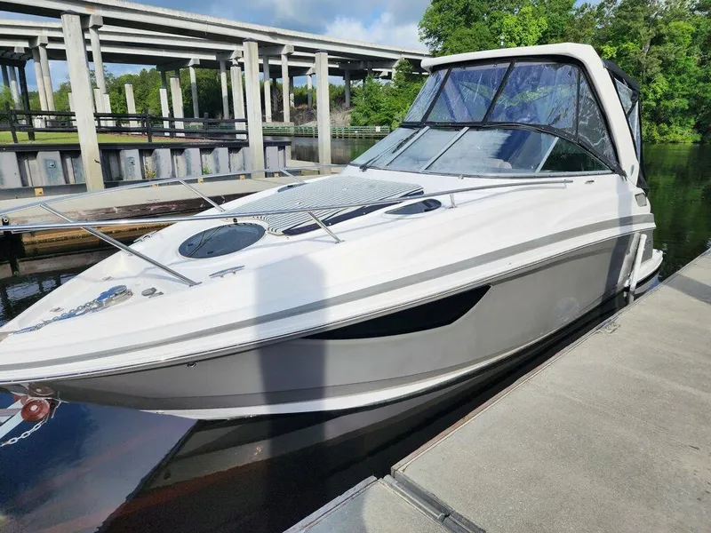 Slide: The Image of 2015 Regal 28 Express boat docked near a bridge on a sunny day. - 0
