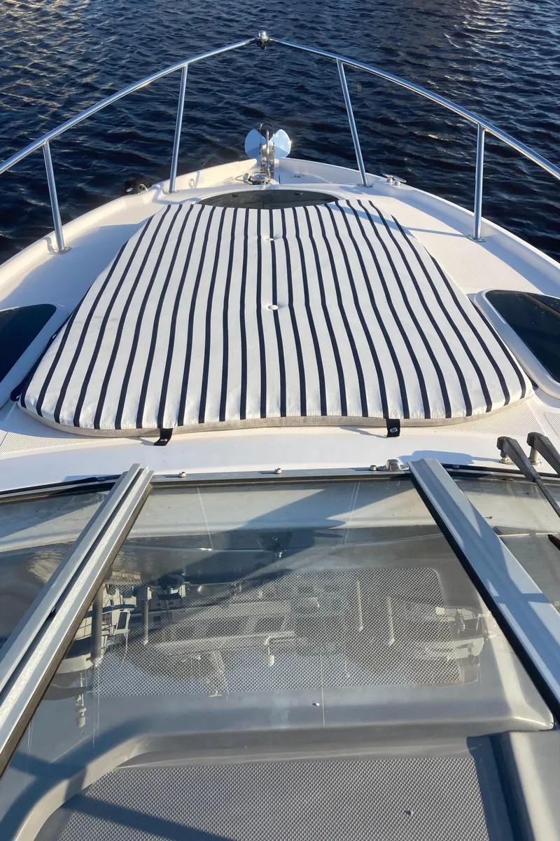 Slide: The Image of 2015 Regal 28 Express boat with striped sun pad on deck. - 12