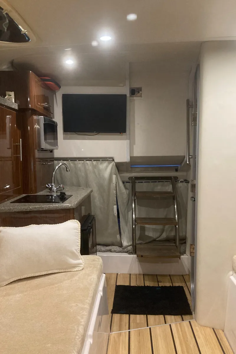 Slide: The Image of Interior of 2015 Regal 28 Express boat with kitchenette and seating area. - 17