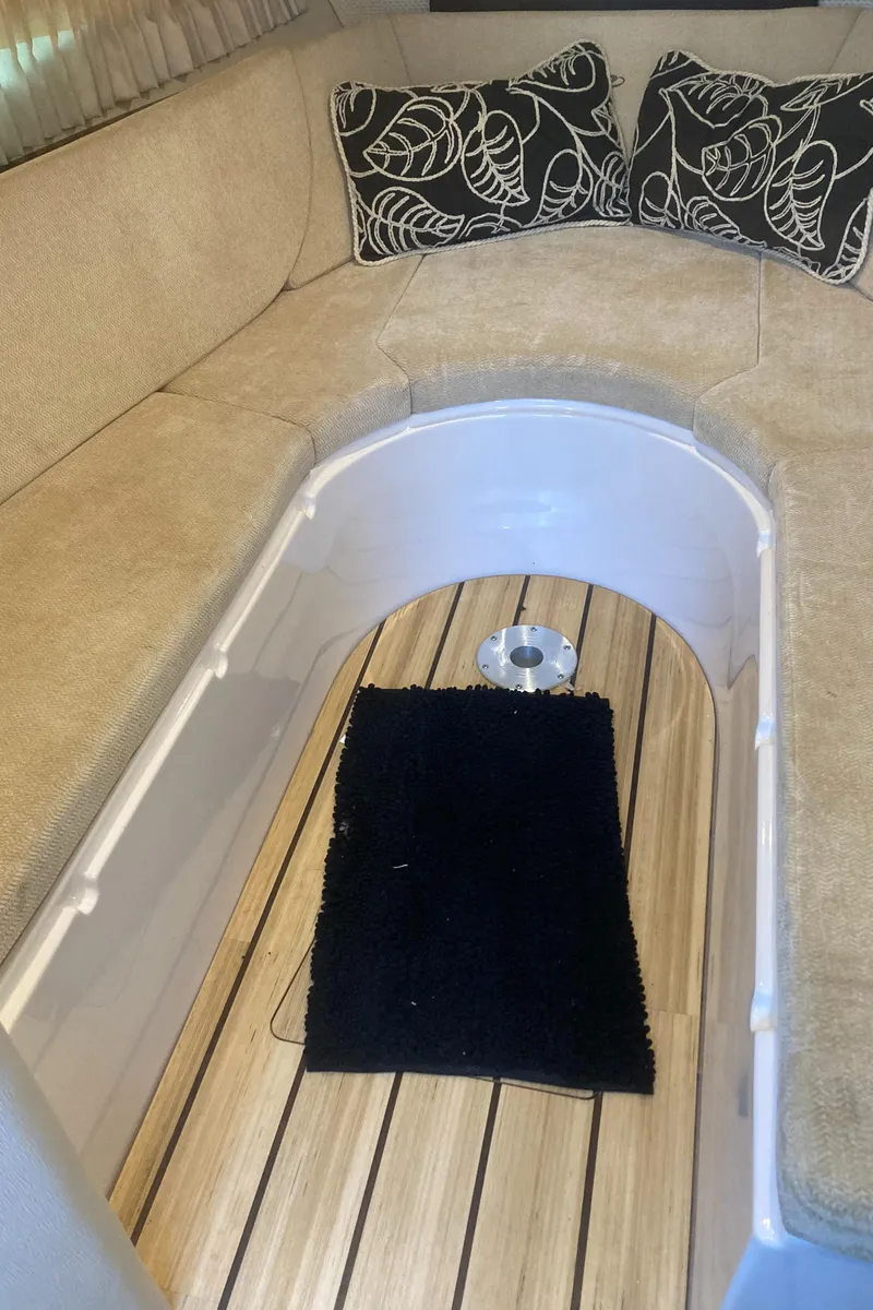 Slide: The Image of 2015 Regal 28 Express cabin interior with beige seating and decorative pillows. - 18