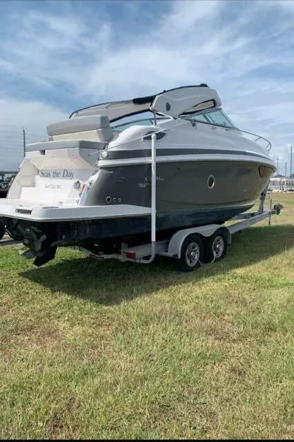 Slide: The Image of 2015 Regal 28 Express boat on trailer, parked on grass under a clear sky. - 20