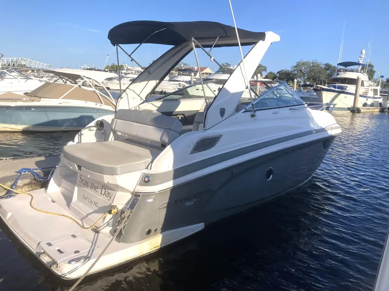 Slide: The Image of 2015 Regal 28 Express boat docked at marina with other boats. - 3