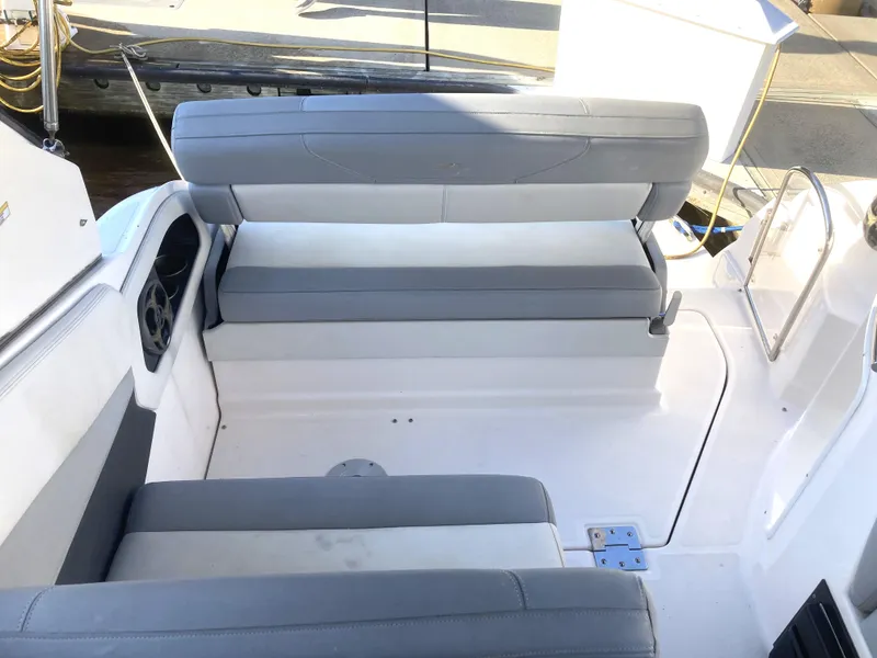 Slide: The Image of 2015 Regal 28 Express boat interior seating area with gray cushions. - 6