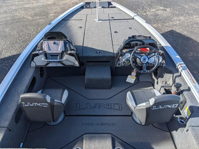 Slide: The Image of 2025 Lund 1875 Pro V Bass boat interior with dual seats and modern dashboard. - 7