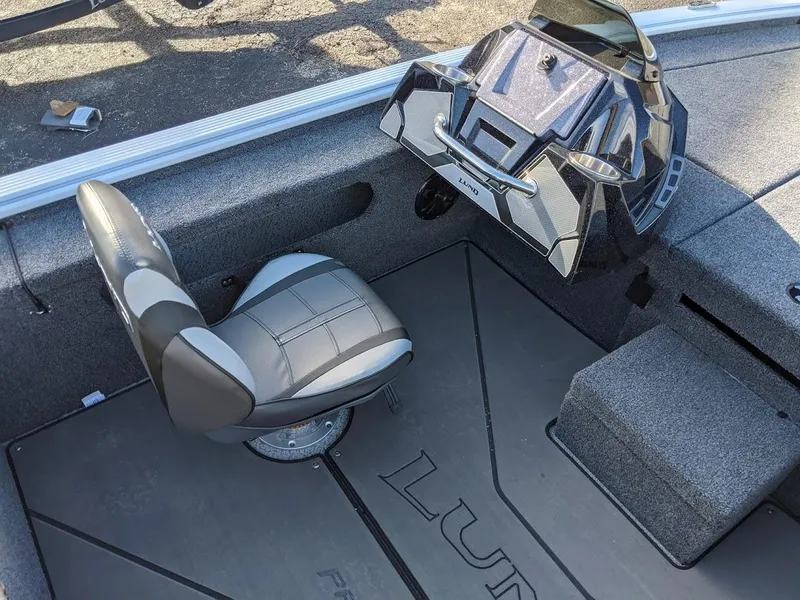 Slide: The Image of 2025 Lund 1875 Pro V Bass boat interior with captain's seat and console. - 9