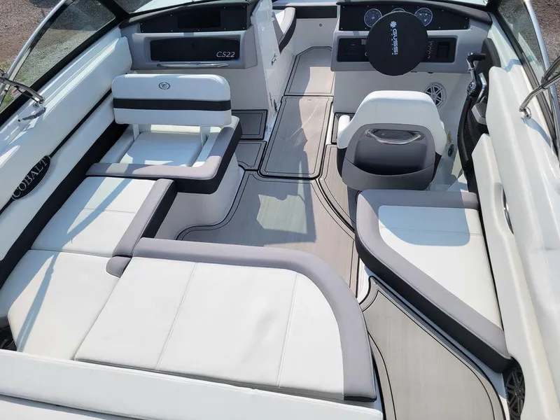 Slide: The Image of 2024 Cobalt CS22 boat interior with white and gray seating and modern dashboard. - 12
