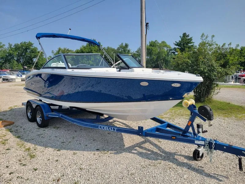 Slide: The Image of 2024 Cobalt CS22 boat on a blue trailer, parked outdoors. - 15