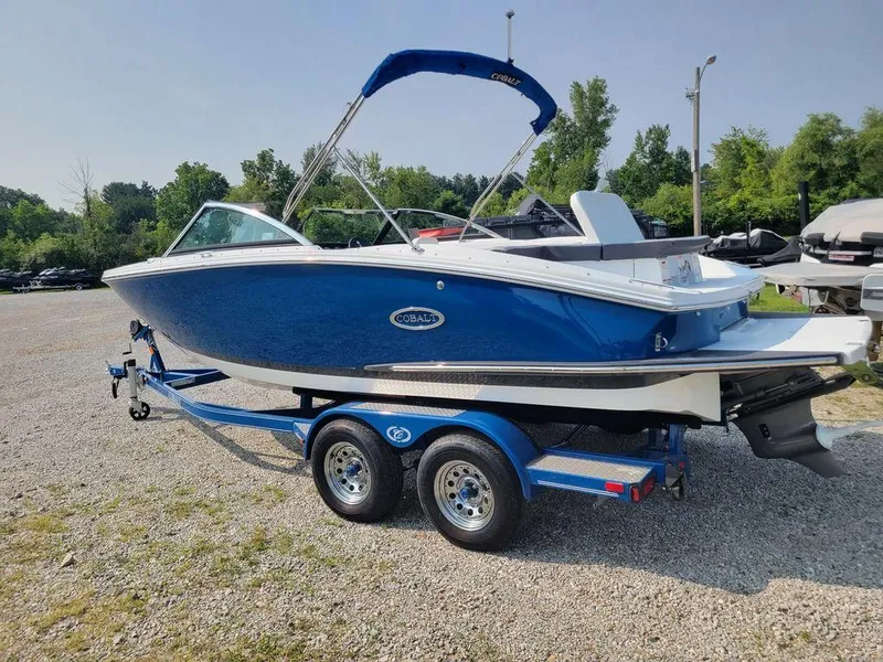 Slide: The Image of 2024 Cobalt CS22 boat on a trailer in a gravel lot. - 3
