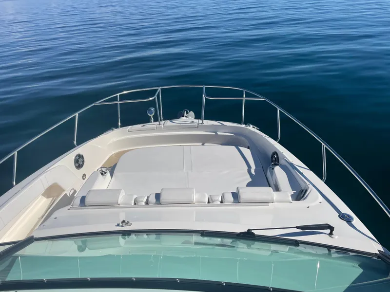 Slide: The Image of The image shows the bow of a 2020 Sea Ray Sundancer 320 on calm water. - 8