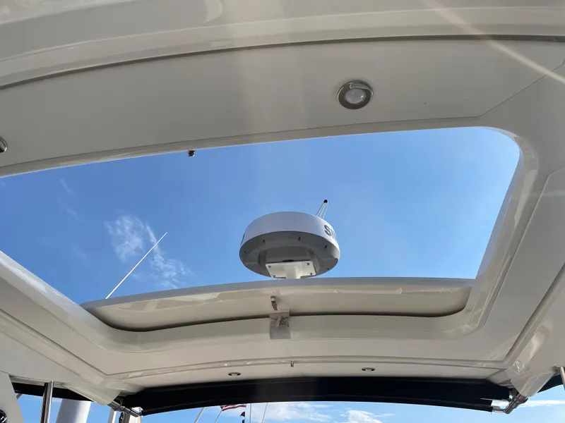 Slide: The Image of View through an open sunroof of a Sea Ray Sundancer 320, with blue sky in the background. - 26