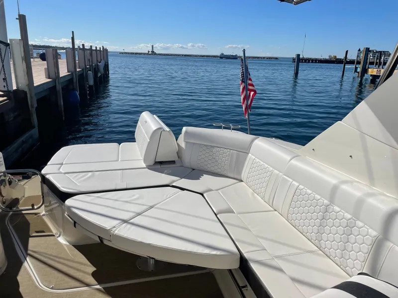 Slide: The Image of The 2020 Sea Ray Sundancer 320 features luxurious white upholstery in the aft area by the water. - 22