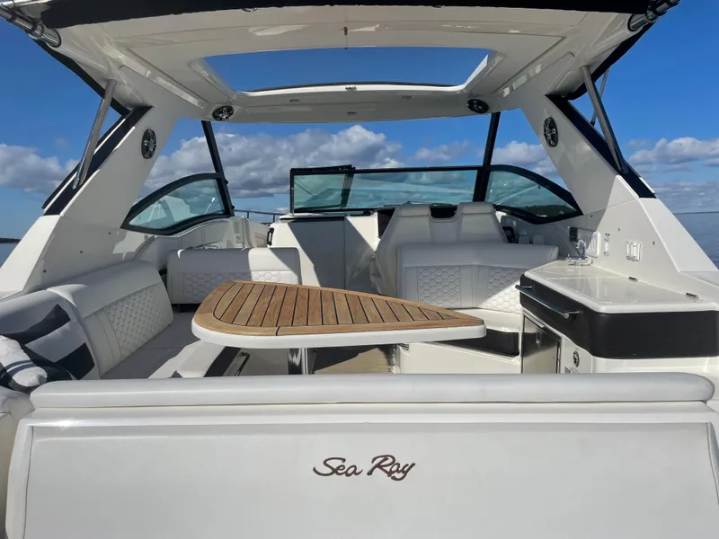 Slide: The Image of The image shows the cockpit of a 2020 Sea Ray Sundancer 320 with a sleek wooden table. - 33