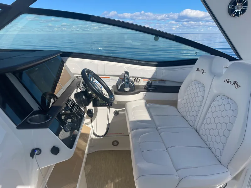 Slide: The Image of The cockpit of the 2020 Sea Ray Sundancer 320 features white upholstered seats and a modern helm. - 10