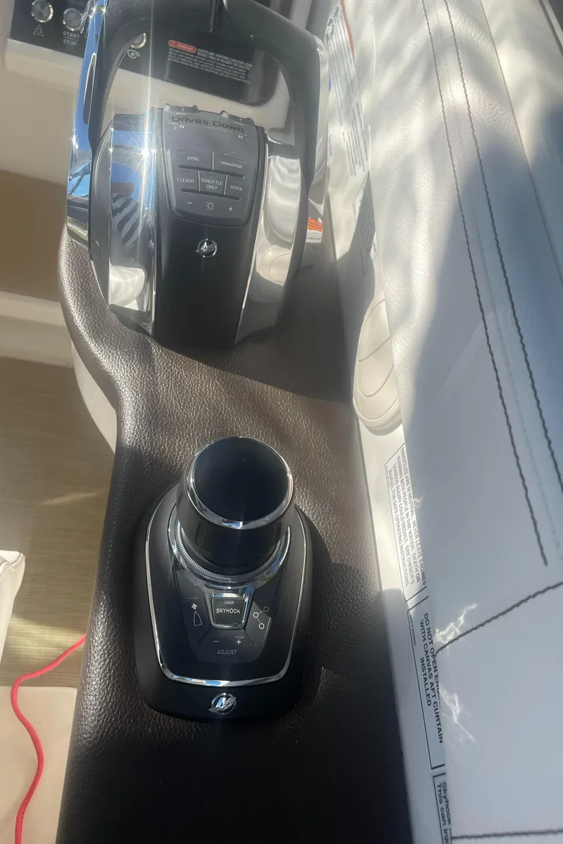 Slide: The Image of Close-up of the helm console on a 2020 Sea Ray Sundancer 320, featuring modern controls. - 11