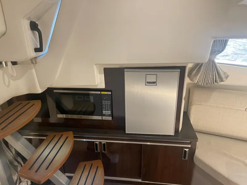 Slide: The Image of Interior of a 2020 Sea Ray Sundancer 320 with a microwave and refrigerator. - 29