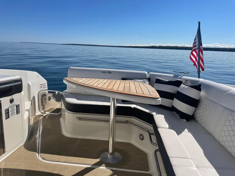 Slide: The Image of The 2020 Sea Ray Sundancer 320 features an elegant seating area with a wooden table and cushions. - 20