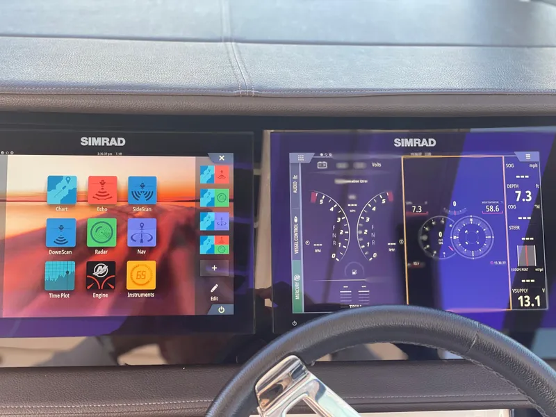 Slide: The Image of The image shows the dashboard of a Sea Ray Sundancer 320 with two Simrad screens. - 12
