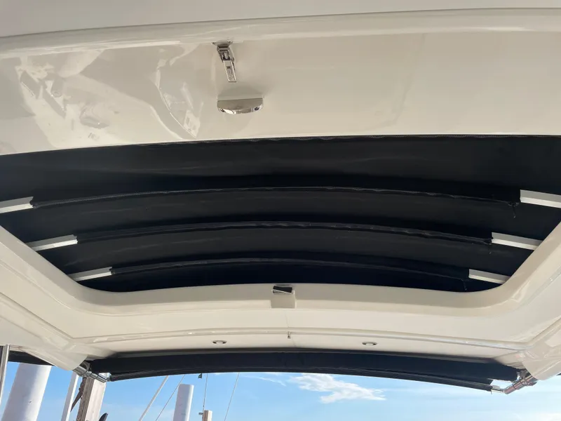 Slide: The Image of The image shows the open canopy of a 2020 Sea Ray Sundancer 320. - 25