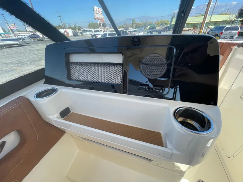 Slide: The Image of 2024 Scout 277 Dorado boat dashboard with cup holders and storage compartments. - 14