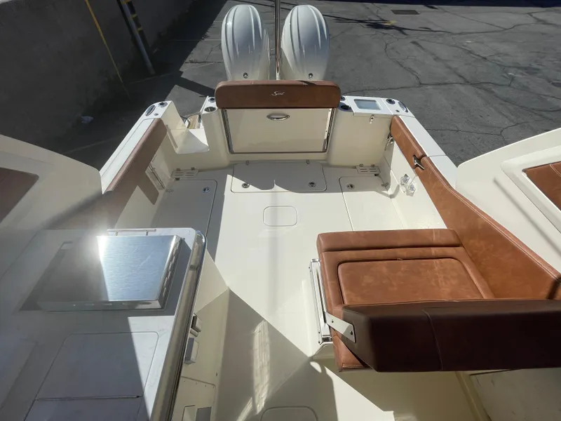 Slide: The Image of 2024 Scout 277 Dorado boat interior with twin engines and brown leather seating. - 15