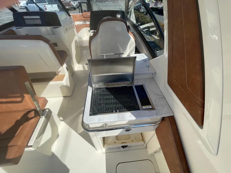 Slide: The Image of 2024 Scout 277 Dorado boat interior with seating and built-in grill. - 6